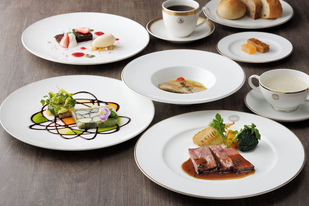 Una mesa con diferentes platos de comida y vasos de bebidas.