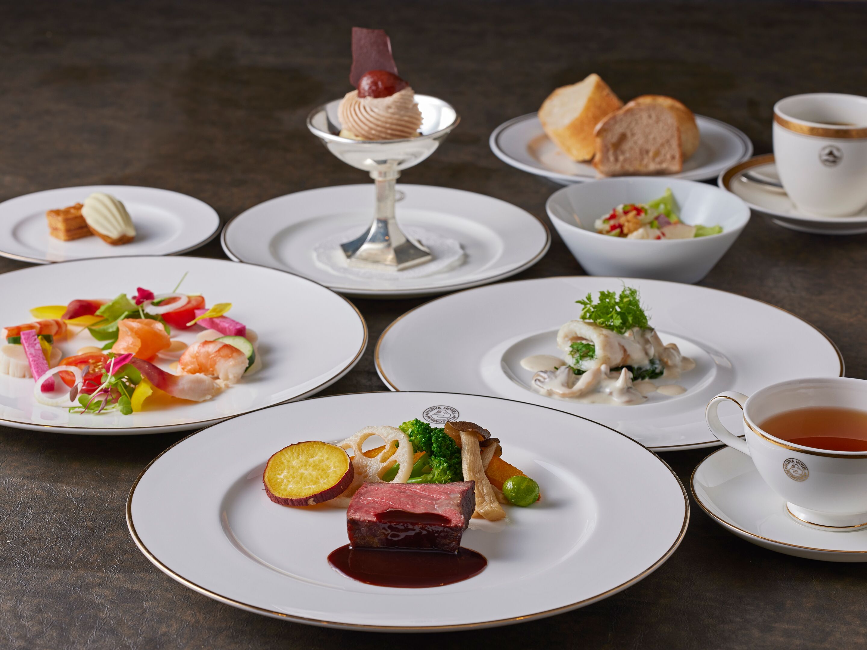 Verschillende gerechten op schotels en een kop thee op een tafel.