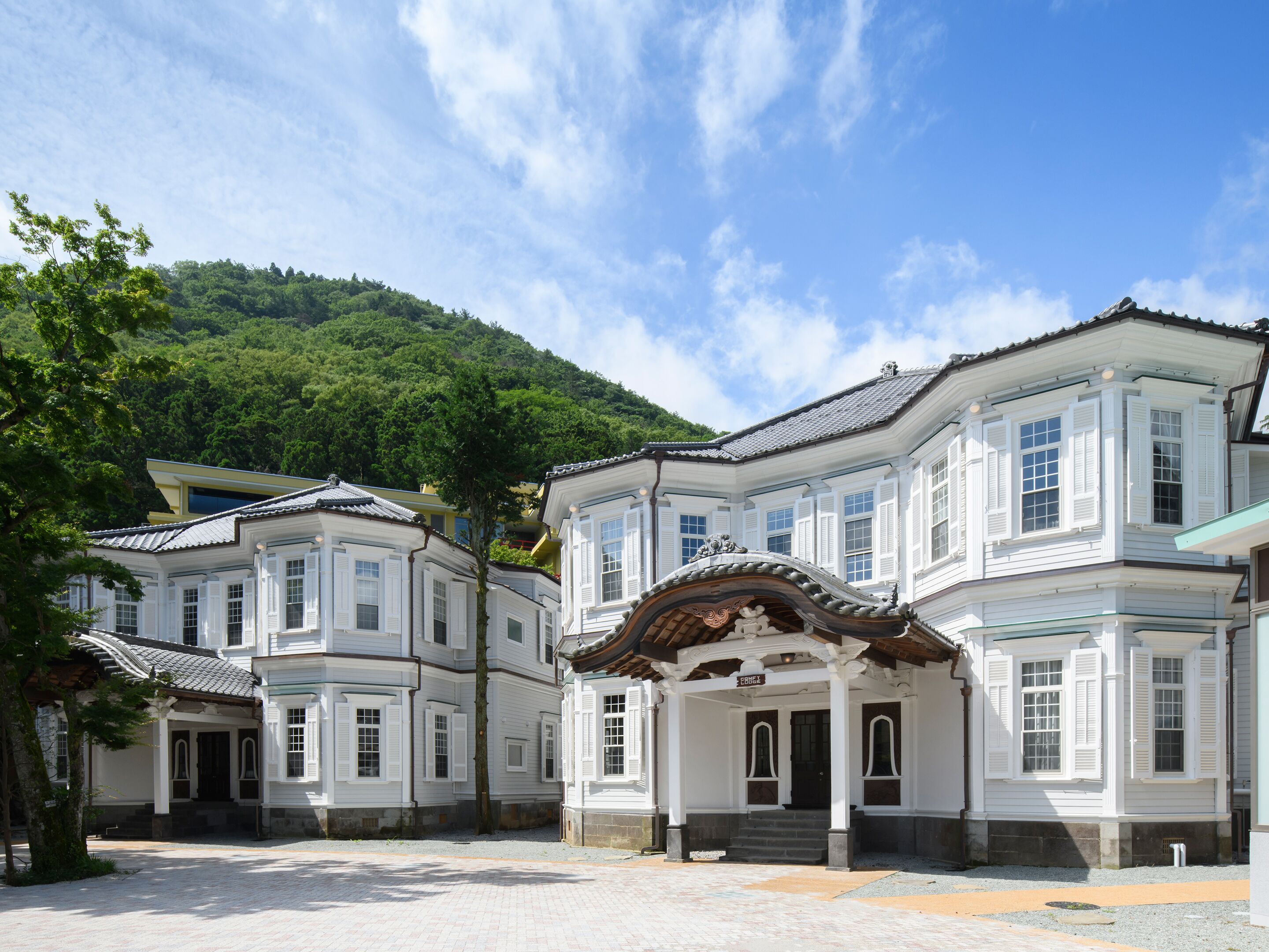 A traditional building with a symmetrical facade, multiple windows, and a central entrance with steps.