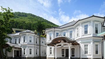 A traditional building with a symmetrical facade, multiple windows, and a central entrance with steps.