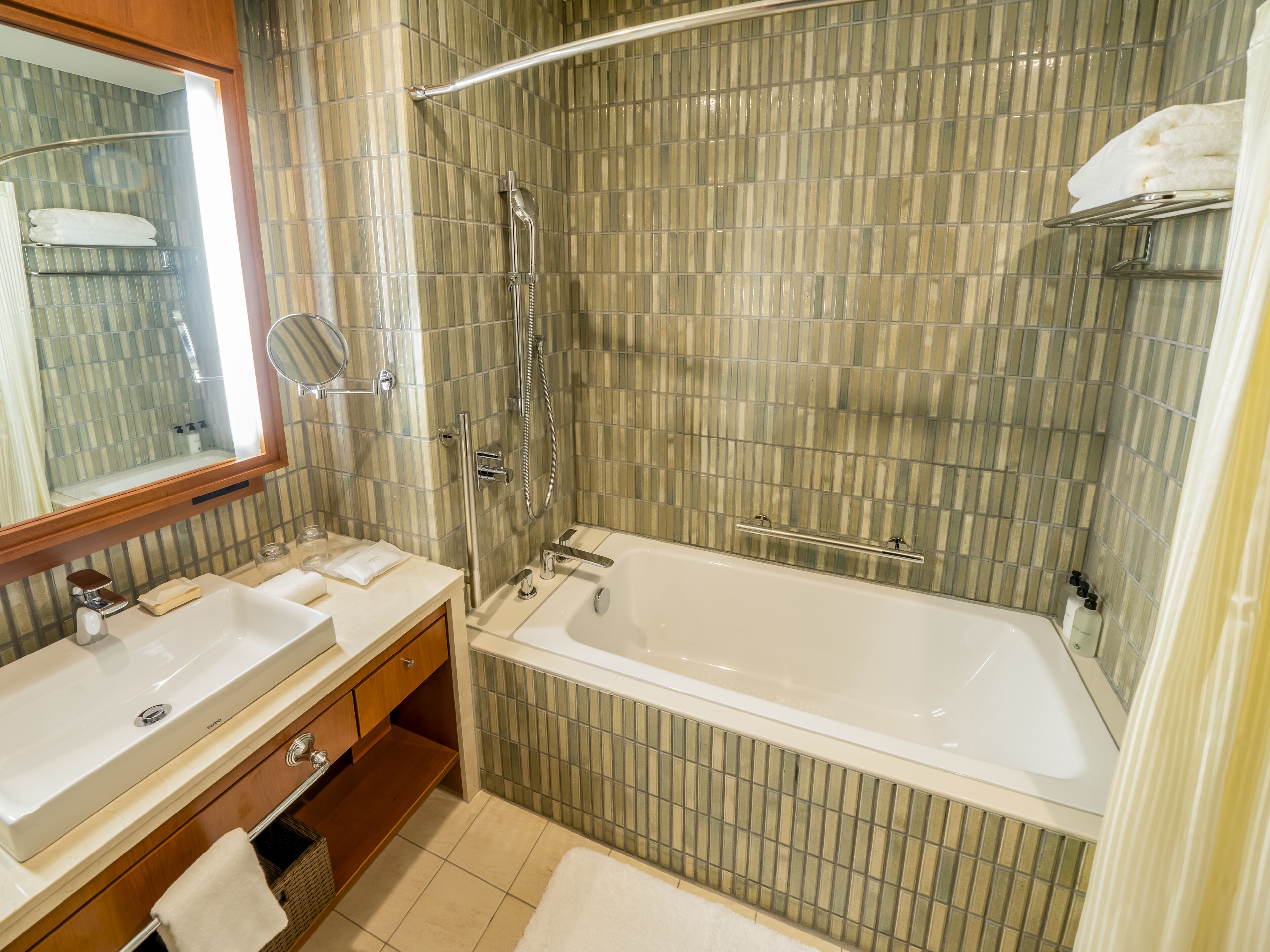 A modern bathroom with two sinks, a bathtub, and a shower.
