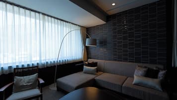 A modern living room with a sofa, armchair, and floor lamp.