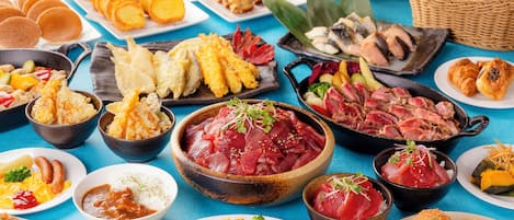 A variety of dishes including sushi, pancakes, and other breakfast items on a table.