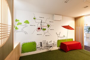 Eine Stadtkarte an der Wand, ein roter Tisch und ein roter Regenschirm.