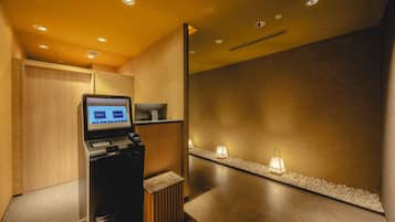 A reception area with a digital kiosk, wooden paneling, and a pebble-lined walkway.