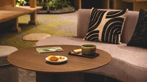 A round table with a magazine, a plate with food, and a cup.