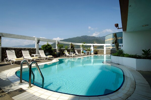 Una piscina al aire libre, tumbonas