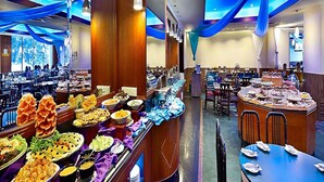 Ein Buffet mit verschiedenen Speisen und eine Sitzgelegenheit mit Tischen und Stühlen.