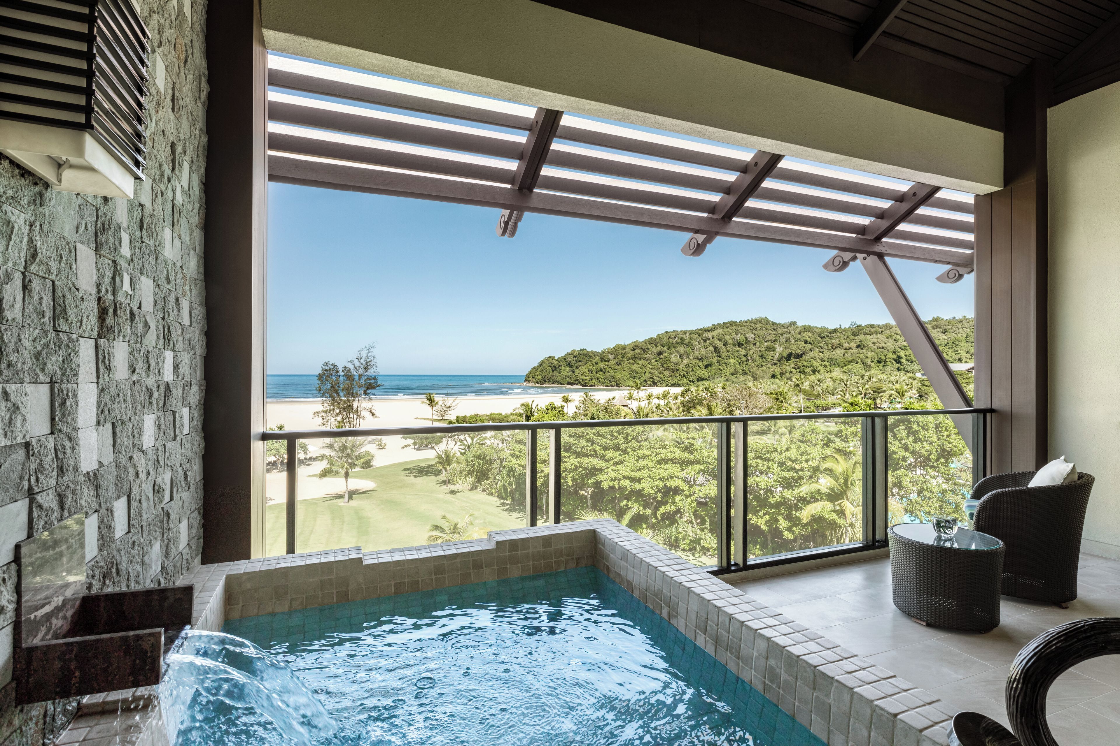 A hot tub with a view of a beach and a golf course.