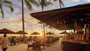 A beachside bar with outdoor seating, palm trees, and string lights. - Shangri-La Rasa Ria, Kota Kinabalu (Tuaran)
