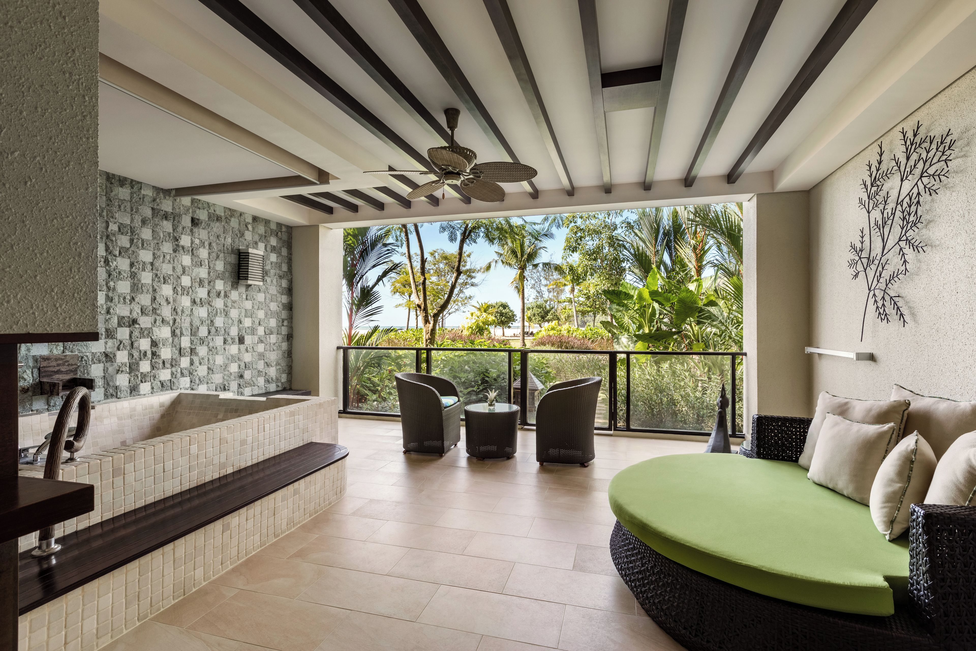 A modern bathroom with a bathtub, a shower, and a large window overlooking a tropical garden.