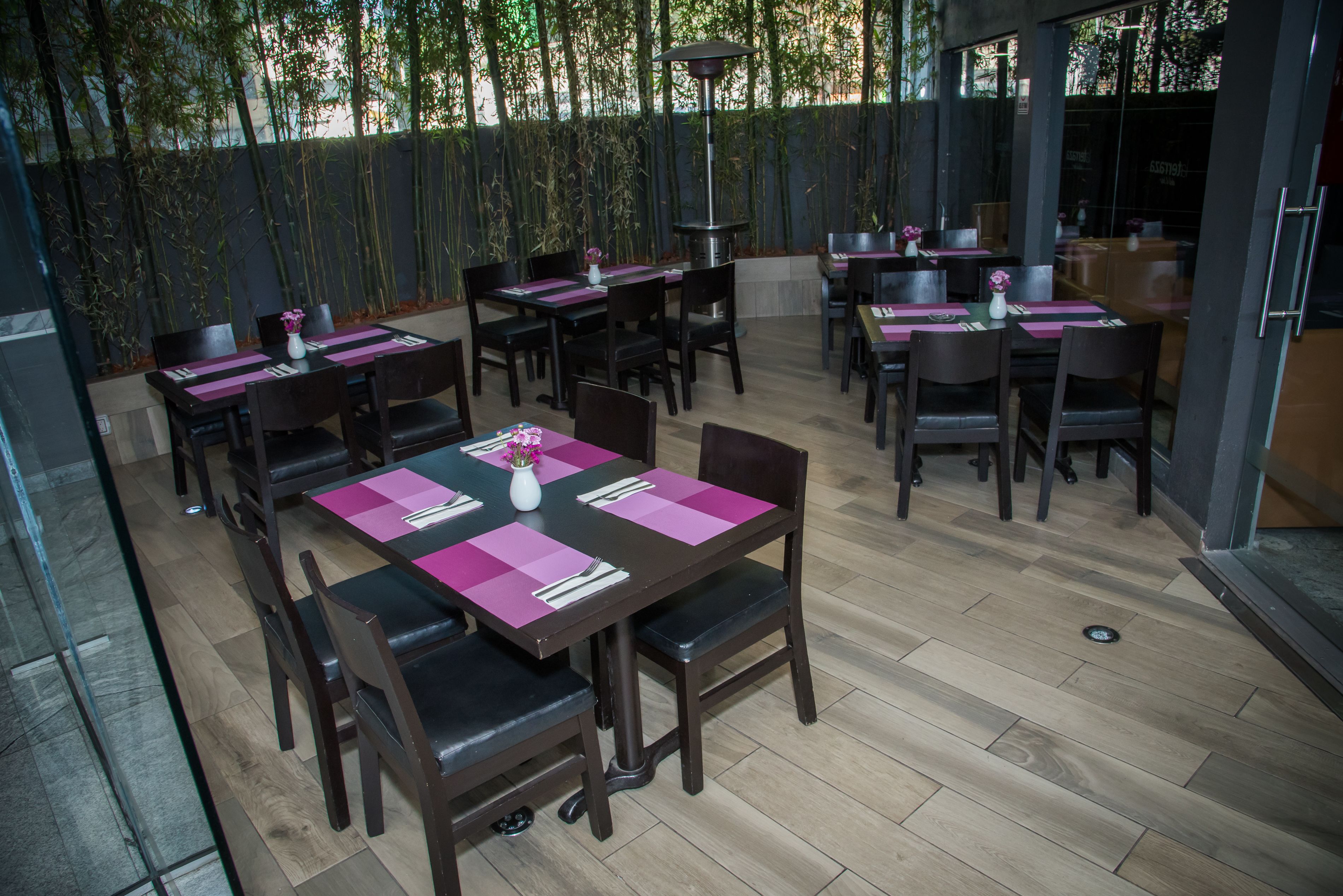 An outdoor dining area with multiple tables and chairs, arranged in a spacious layout.