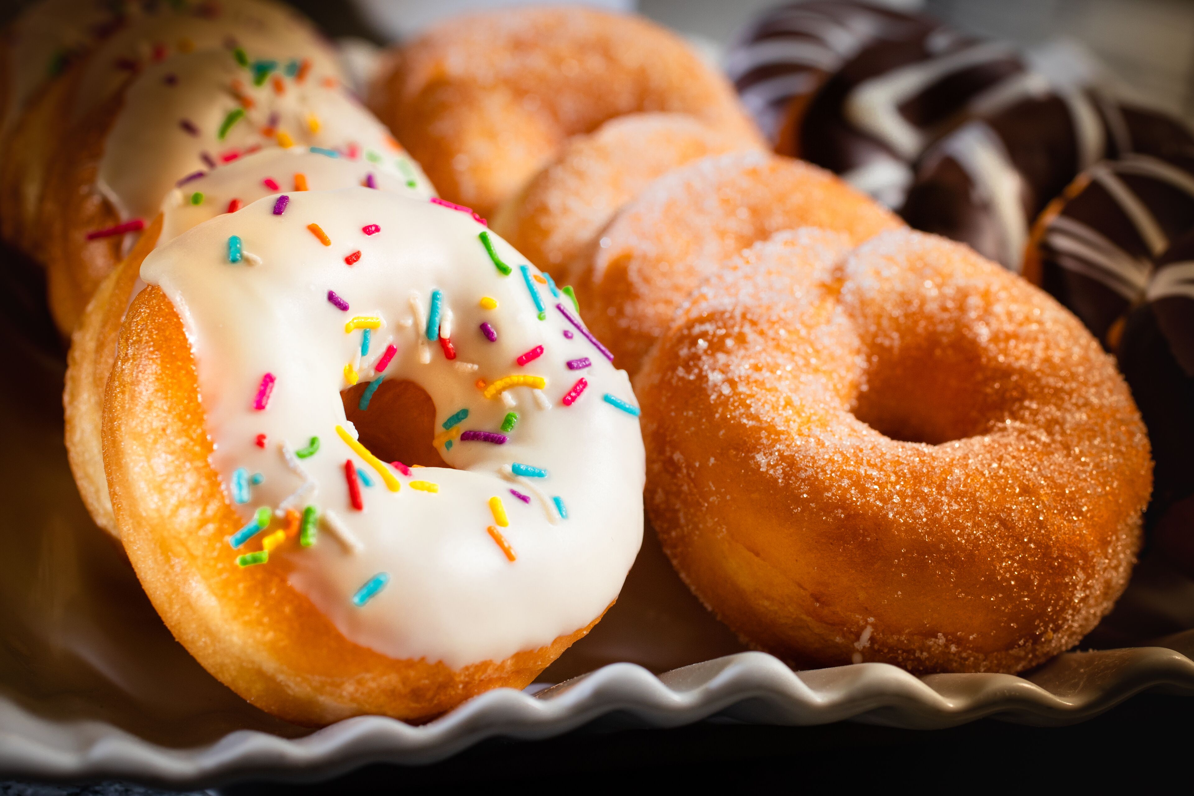A tray of assorted donuts including glazed, frosted, and chocolate varieties.