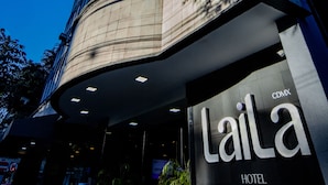 Una entrada de hotel moderna con fachada de vidrio y un letrero que dice "Laila Hotel".