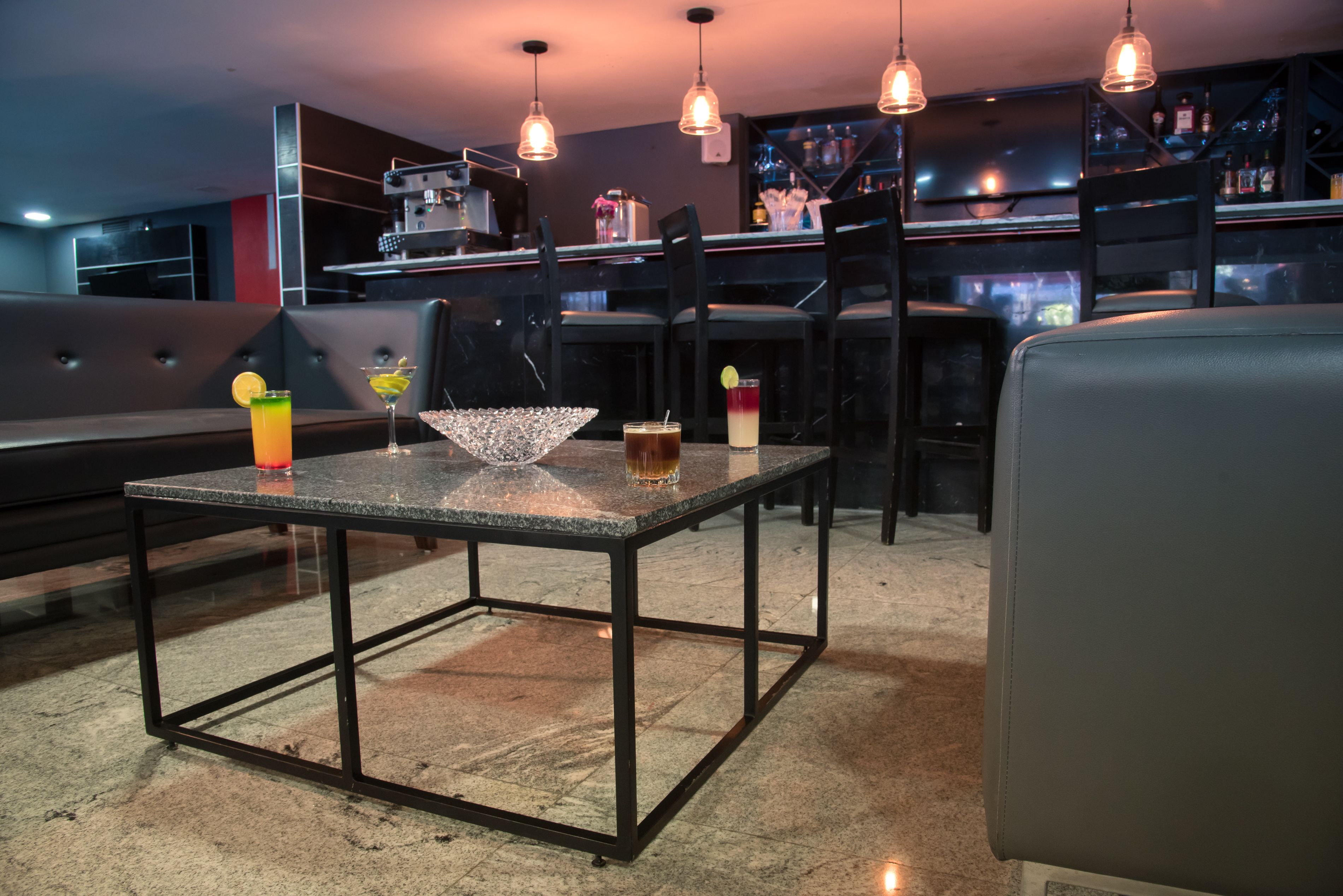 A bar area with a table, chairs, and a bar counter.