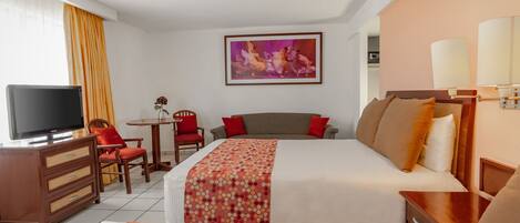 A hotel room with two beds, a TV, a desk, and a chair.