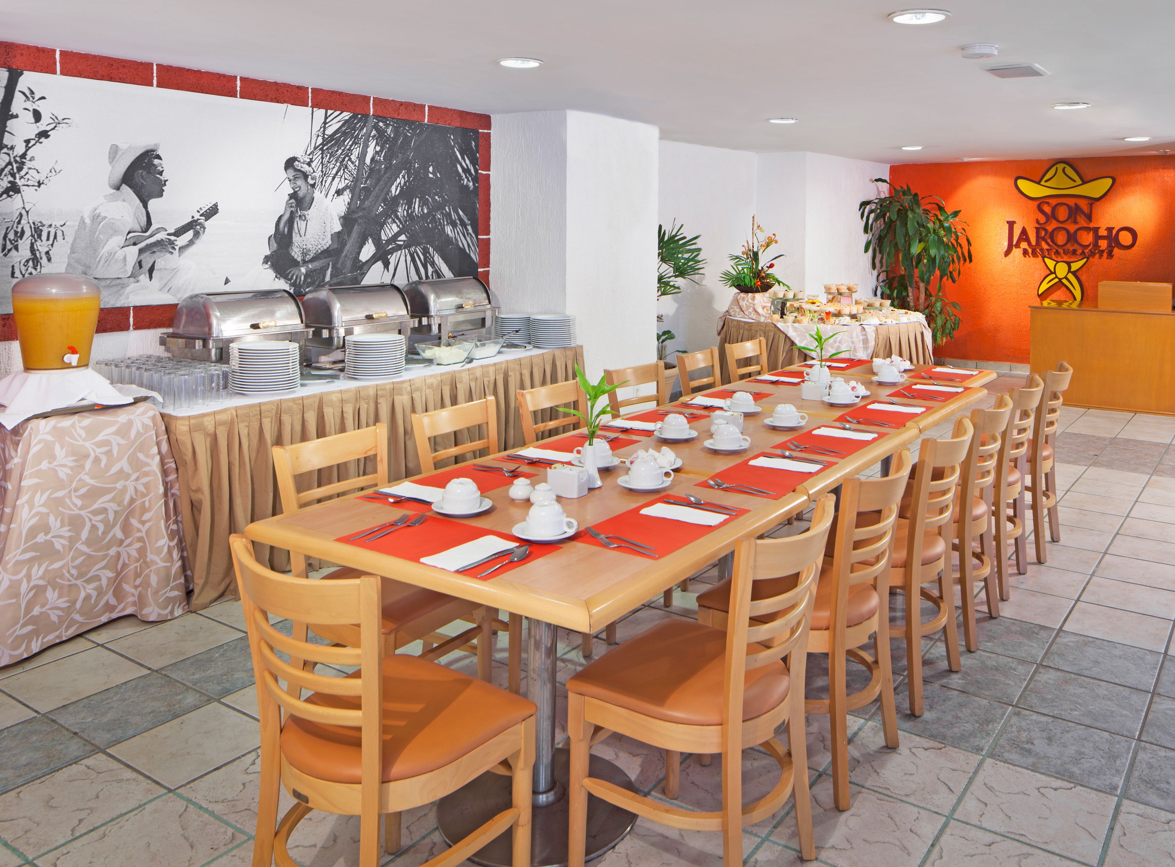 A restaurant with a long dining table set for a meal, surrounded by chairs.