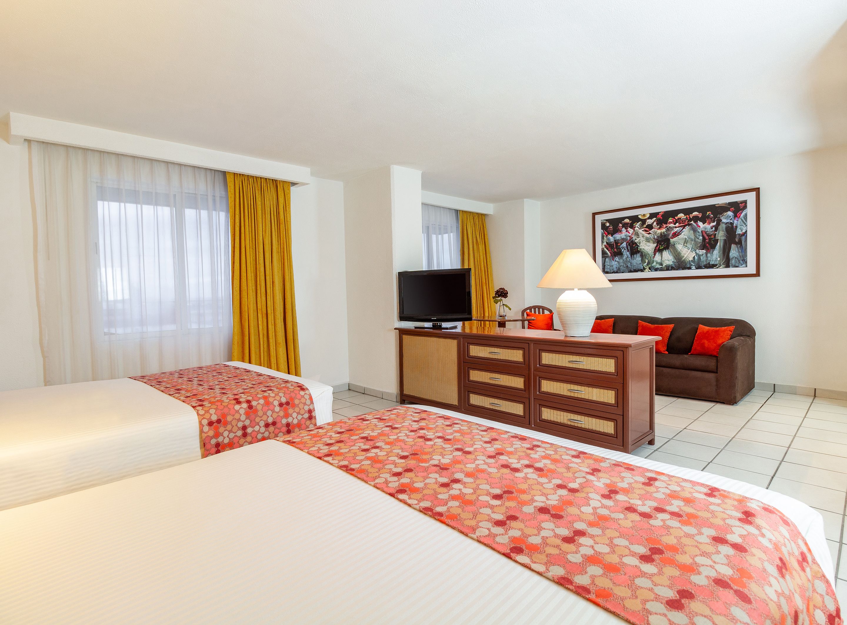 A hotel room with two beds, a TV, a sofa, and a painting on the wall.