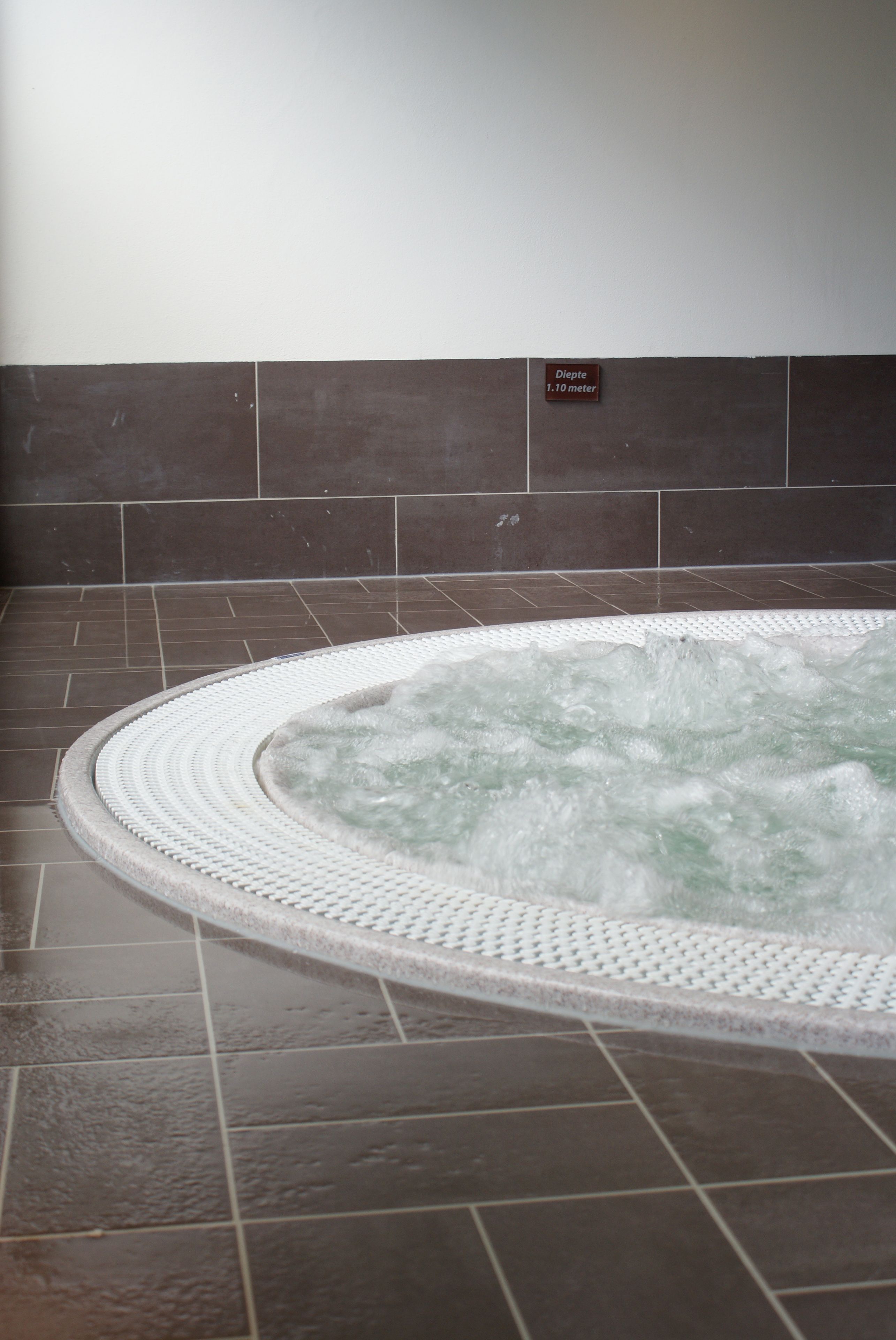 A hot tub with a sign indicating a depth of 1.10 meters.