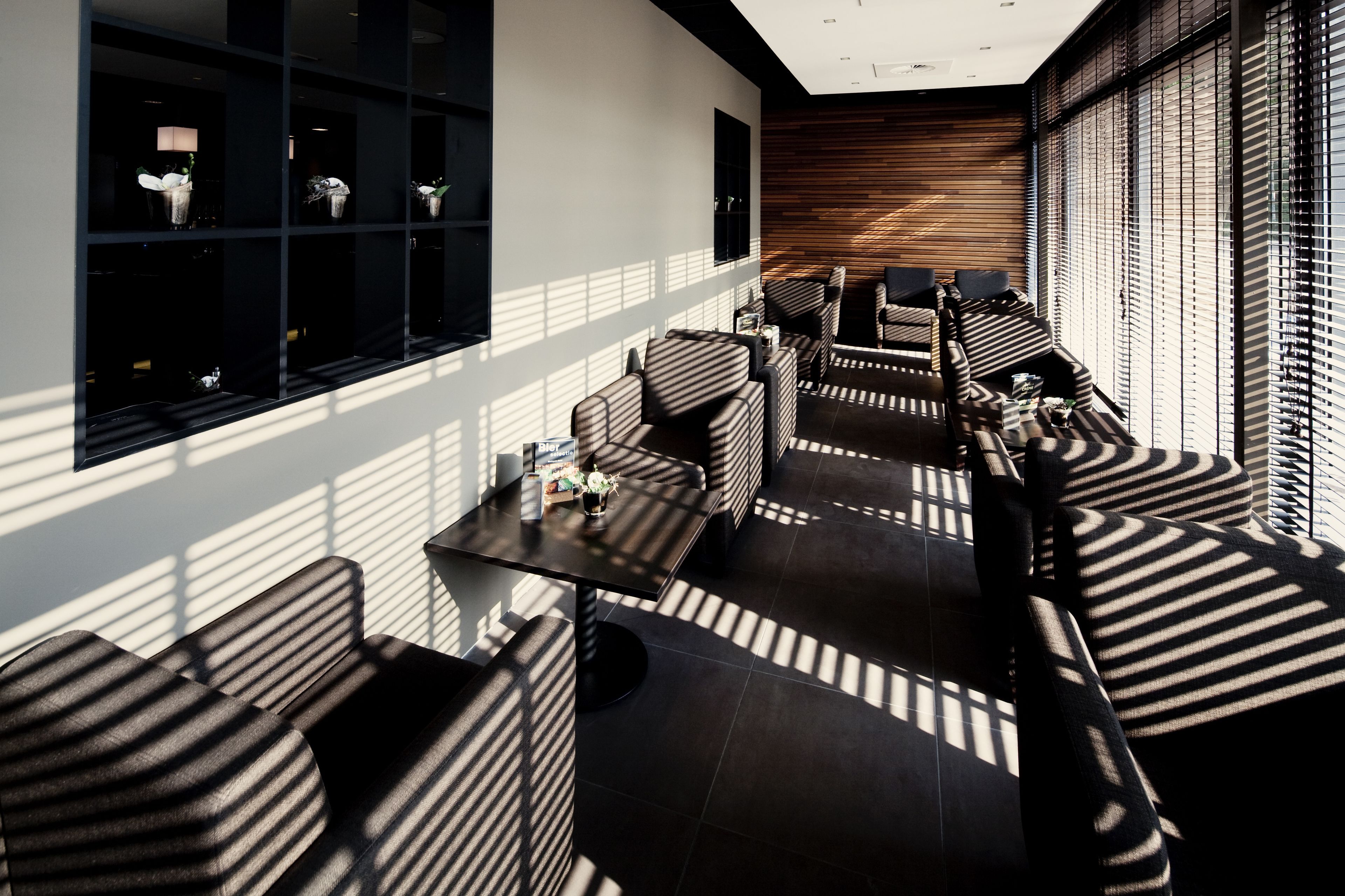 A modern interior with a long sofa, armchairs, and a small table.
