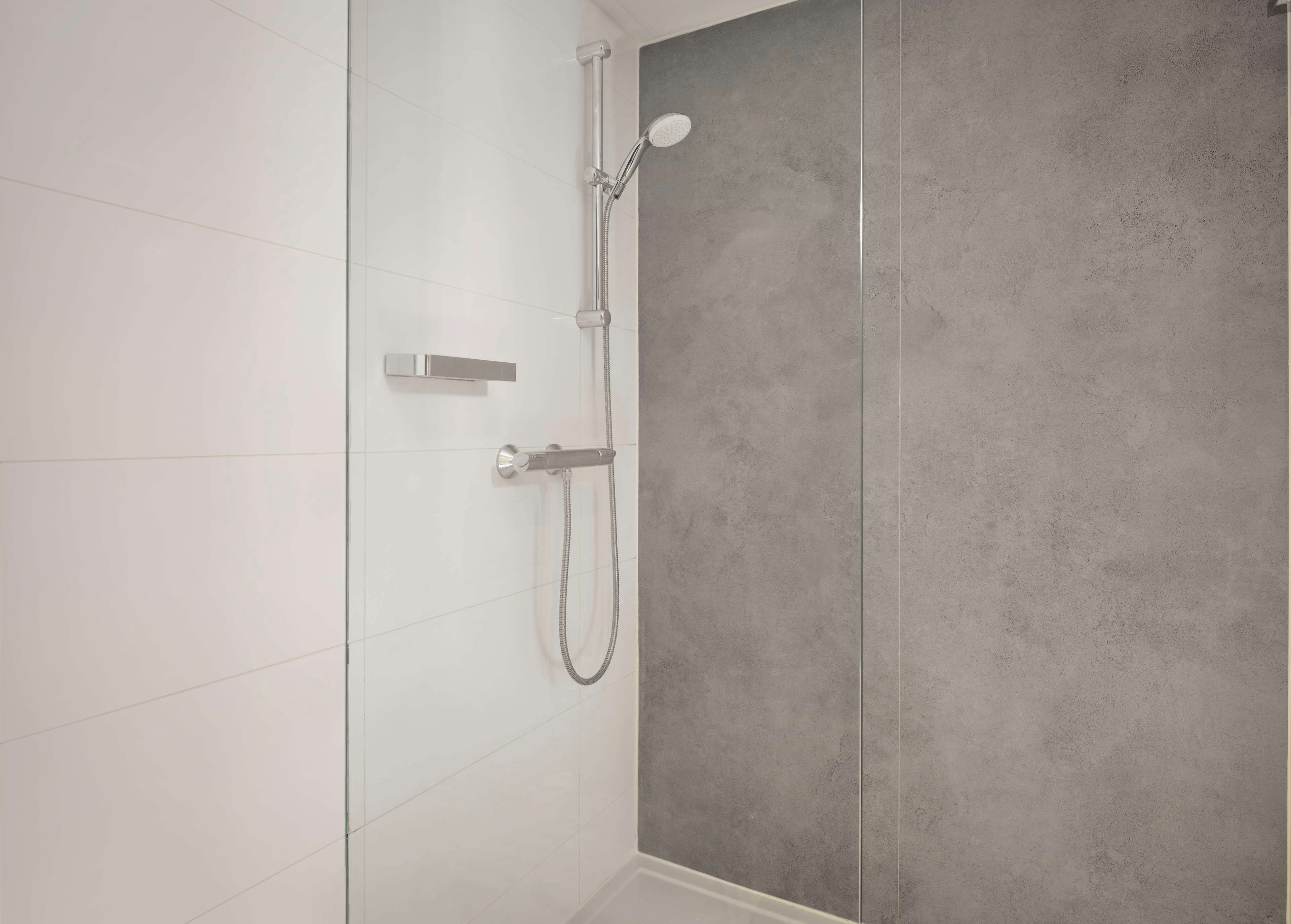 Een moderne badkamer met een douche, handdouche en bedieningspaneel aan de muur.