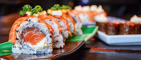 A sushi platter with various types of sushi on a wooden table.