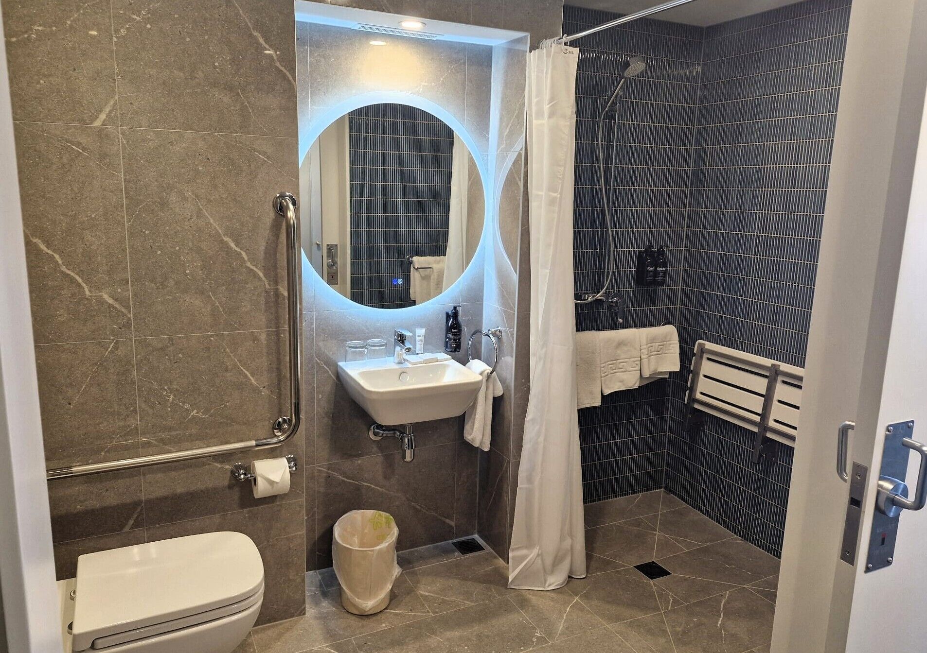 Un baño moderno con ducha, inodoro y lavamanos.