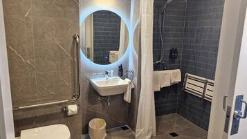 Un baño moderno con ducha, inodoro y lavamanos.
