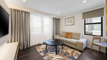 Suite, 1 habitación | Área de sala de estar | Televisión LCD de 32 pulgadas con canales vía satélite y televisión