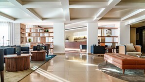 A spacious lobby with a central seating area, a reception desk, and a bar area. - Dom Goncalo Hotel & Spa (Ourem)
