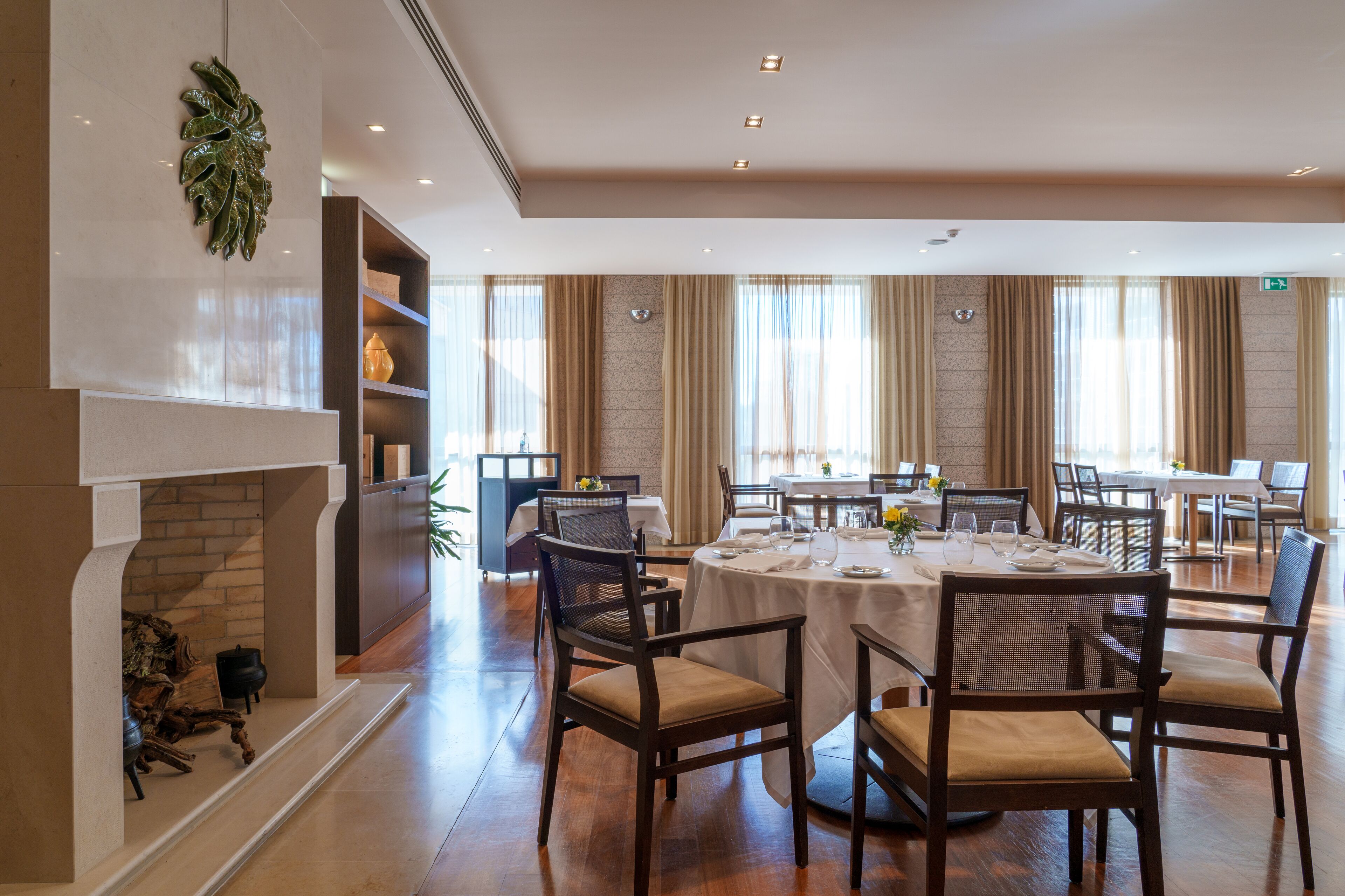 Un comedor espacioso con chimenea, sillas de madera y una gran mesa dispuesta para comer.