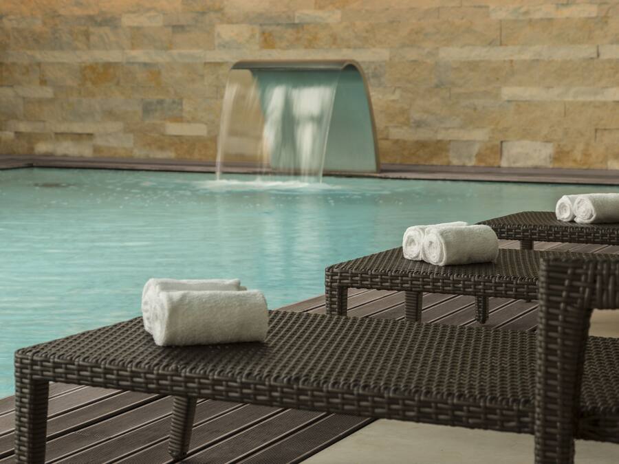 Una piscina techada, sillones reclinables de piscina