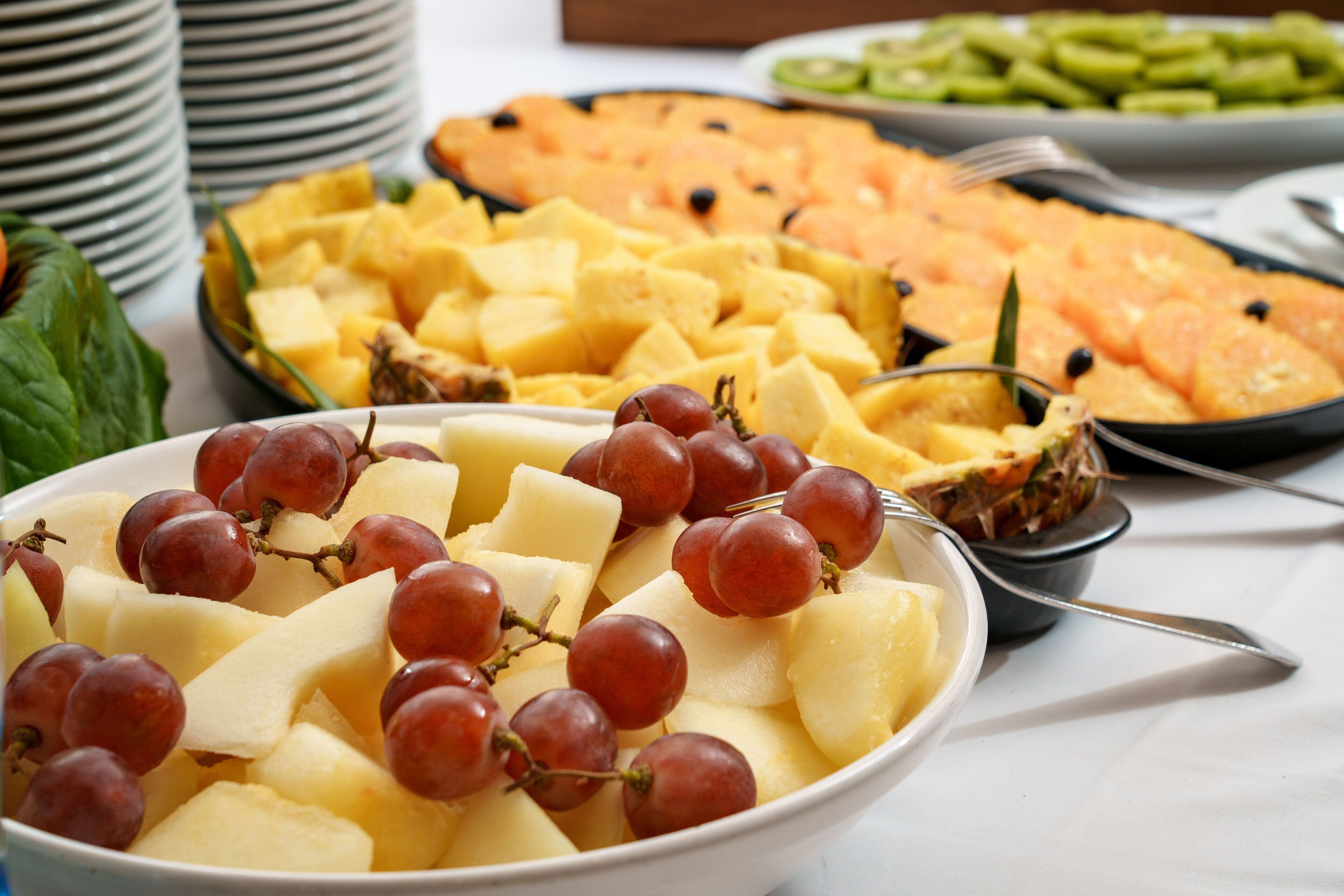 A bowl of fruit salad with grapes and pineapple chunks.