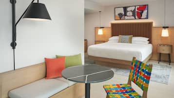 Et hotelværelse med seng, sofa, bord og stol.