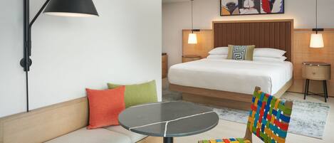 A hotel room with a bed, a sofa, a table, and a chair.