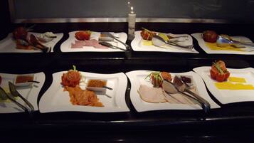 A buffet with various dishes and utensils laid out on plates.