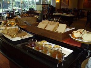 A buffet setup with various food items and condiments. - Southern Sun O.R Tambo (Kempton Park)