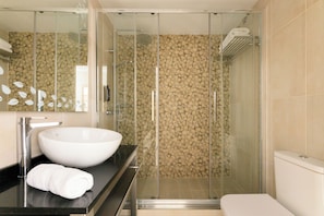 A modern bathroom with a large white sink, a glass shower enclosure, and a toilet. - Hotel Suizo (Barcelona)