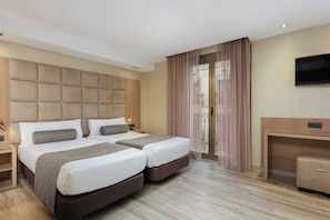 A hotel room with a large bed, a desk, and a TV. - Hotel Suizo (Barcelona)