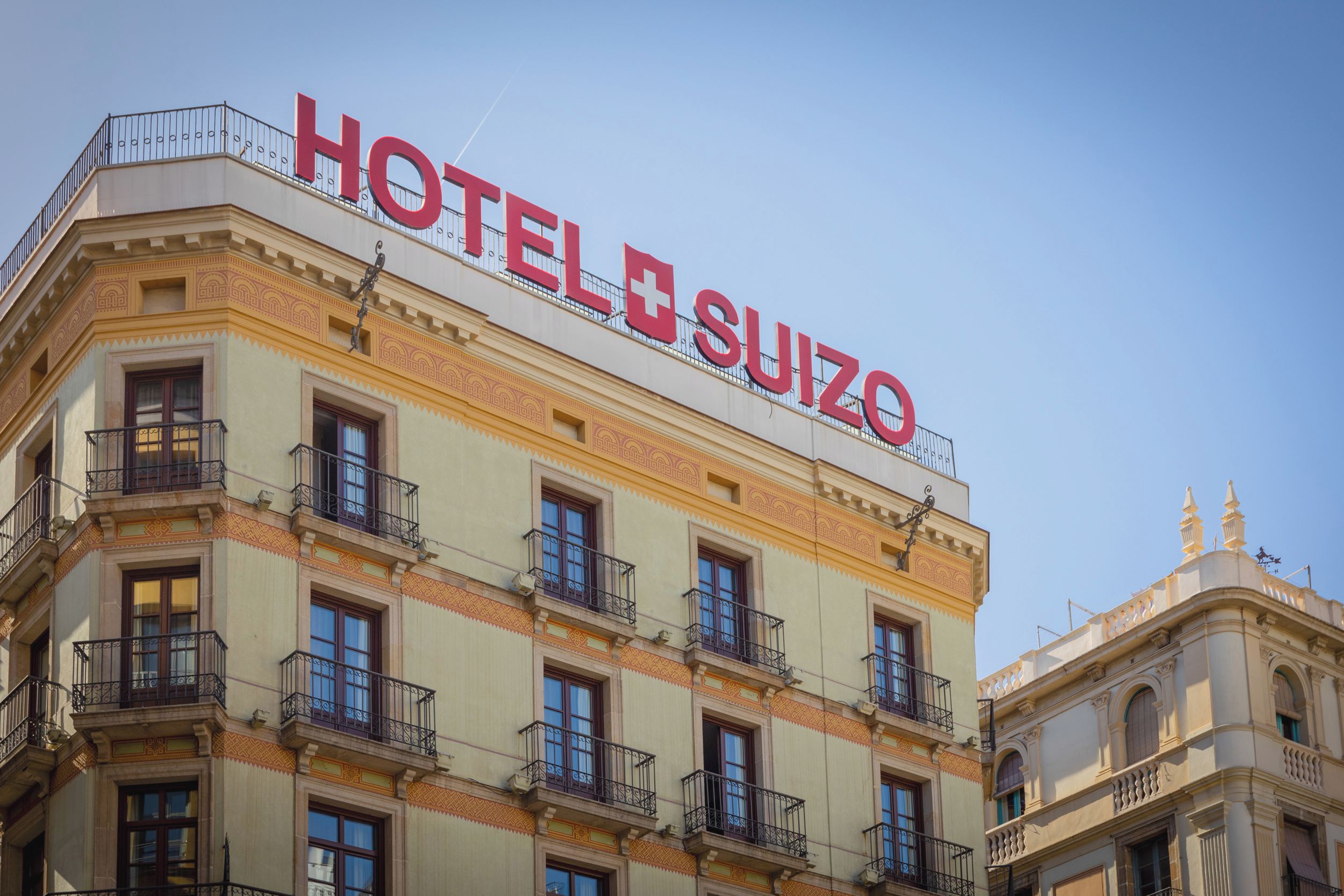 Un bâtiment d’hôtel avec une enseigne bien visible indiquant « HÔTEL SUIZO ».