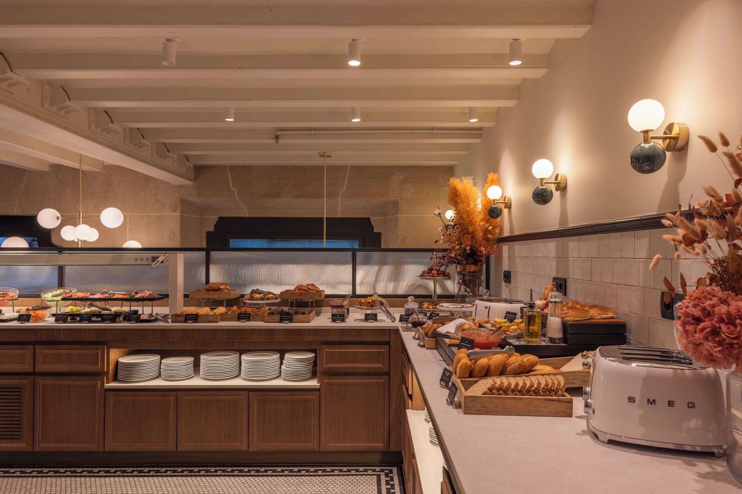 Una cocina moderna con una isla central, presentación de alimentos tipo buffet y un tostador integrado.