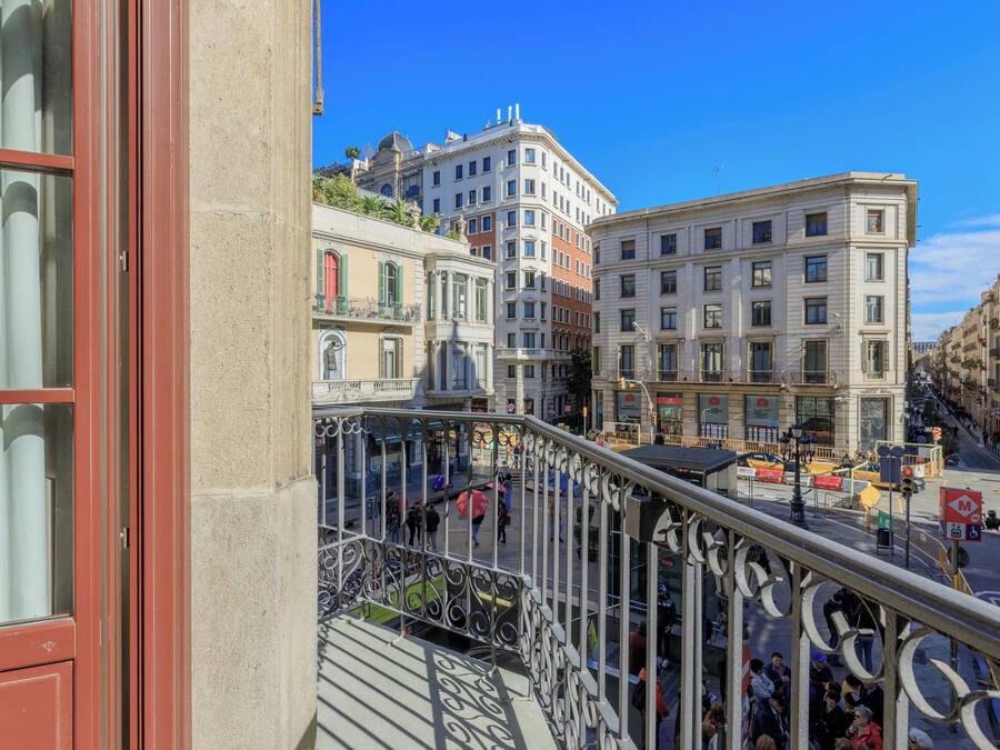 Ruas urbanas com edifícios, zona pedonal e vista de varanda.