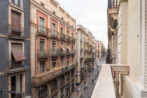 A narrow street lined with multi-story buildings featuring balconies and storefronts.