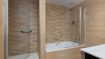 Un baño moderno con ducha envuelta en vidrio, bañera y tocador con espejo.