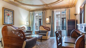 A traditional room with a wooden sofa set, a small table, and a piano. - Rialto (Barcelona)