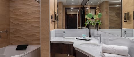 A modern bathroom with a bathtub, two sinks, a large mirror, and a shower area.