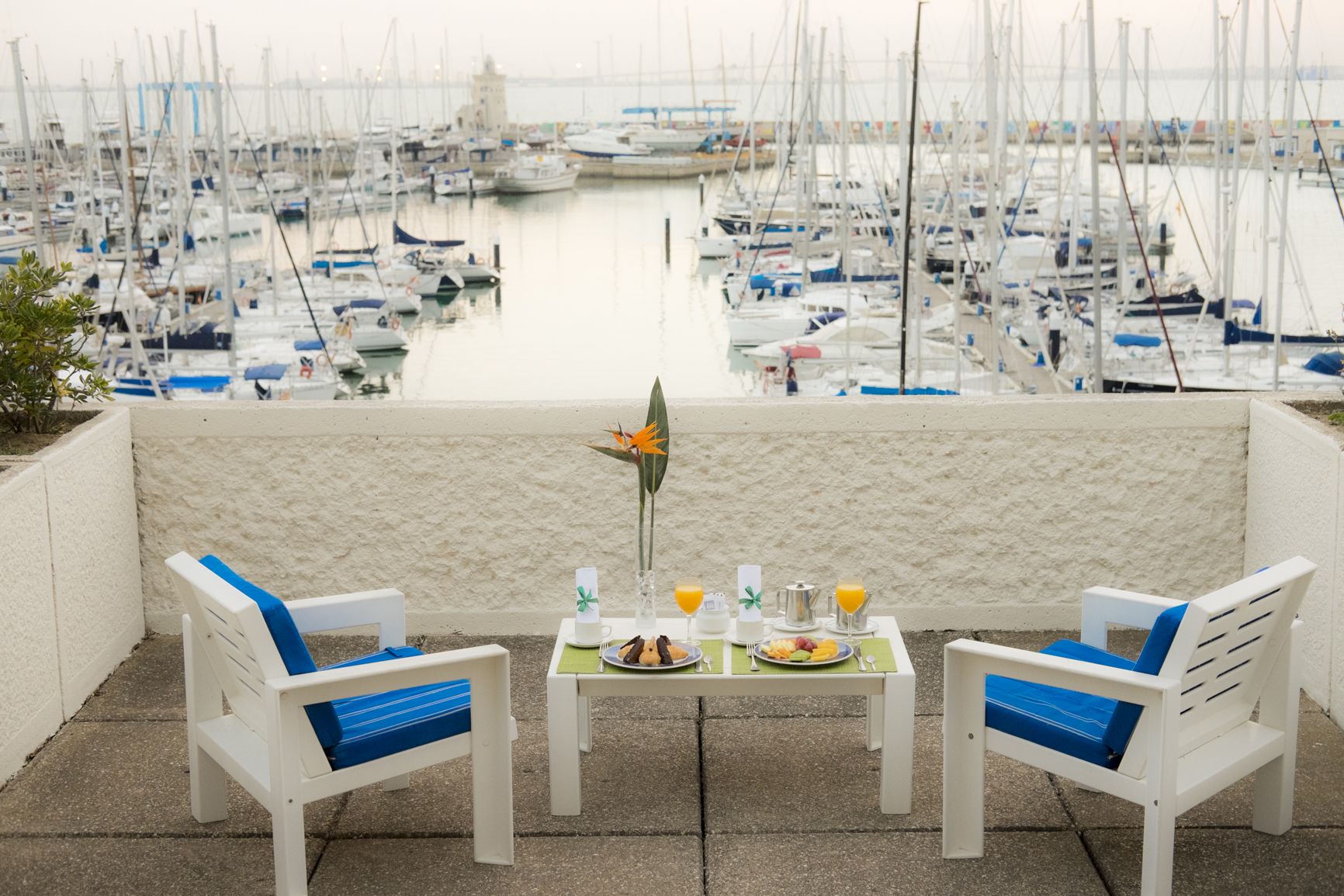 Une table à manger avec des chaises et une vue sur un port de plaisance.