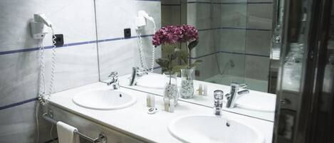 Un baño con dos lavamanos, un espejo y un perchero para toallas.