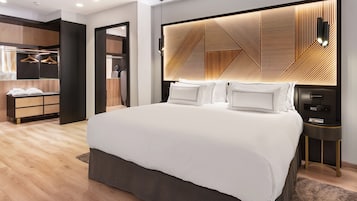 Une chambre moderne dotée d’un grand lit, d’un dressing et d’un décor mural géométrique original.