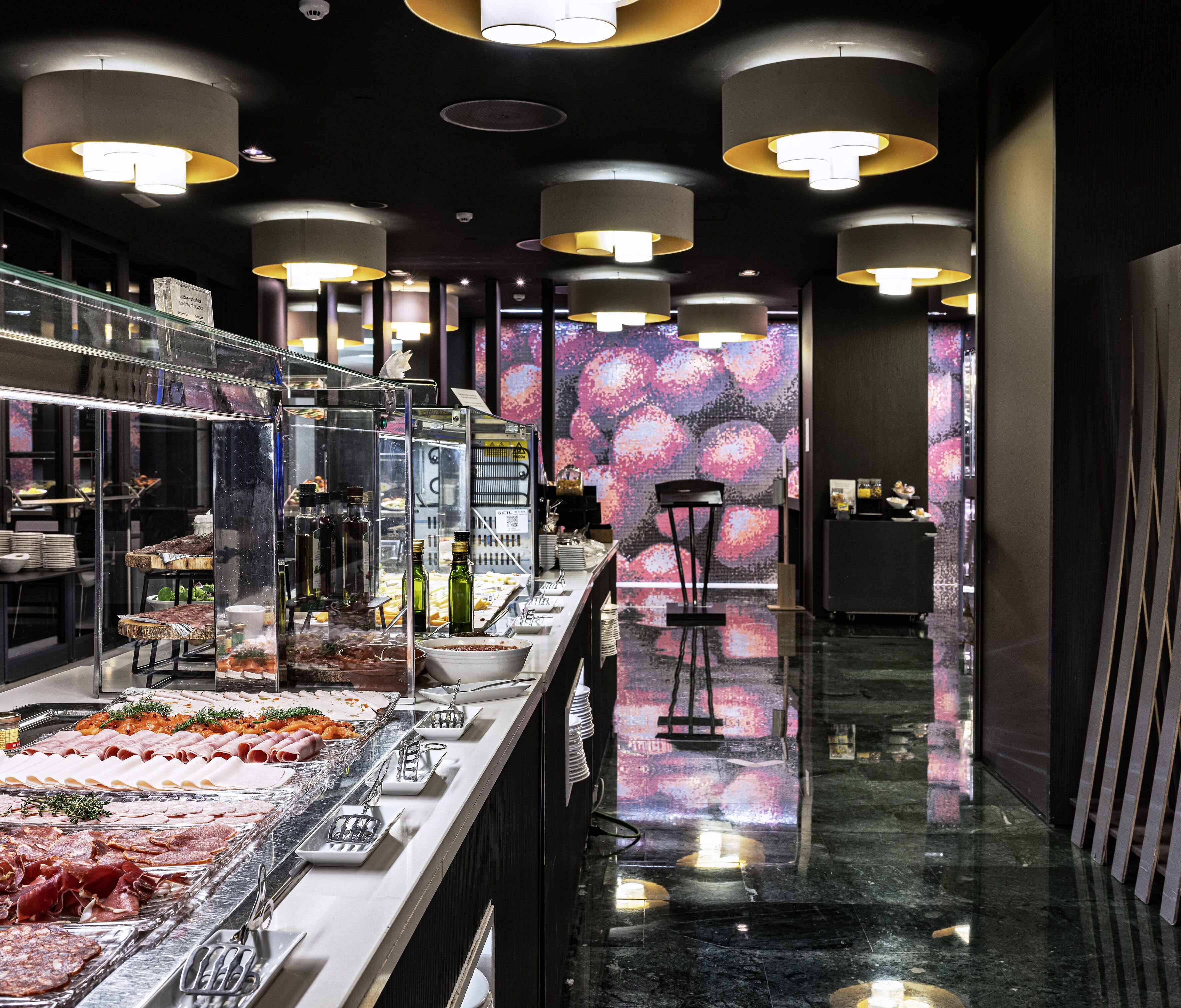 Uma área de buffet com diversos tipos de comida e design de interiores moderno.